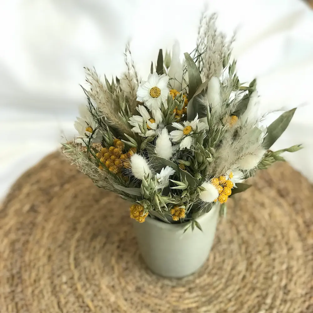centredetable-jaune-naturel composition florale en fleurs séchées jaune et blanche dans un pot en céramique beige