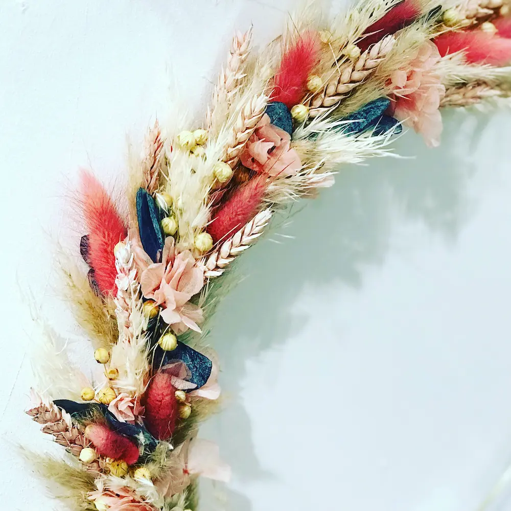 couronne decorative en fleurs séchées colorée, tons bleus rose pâle et corail