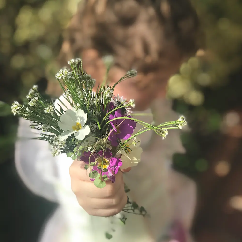 petite fille tenant un bouquet de fleurs du jardin