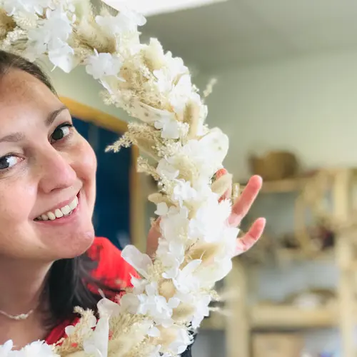 photo de laure bernard qui passe sa tete dans une couronne de fleurs
